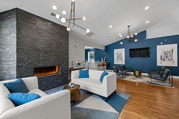 A modern living room with a fireplace and a white couch.